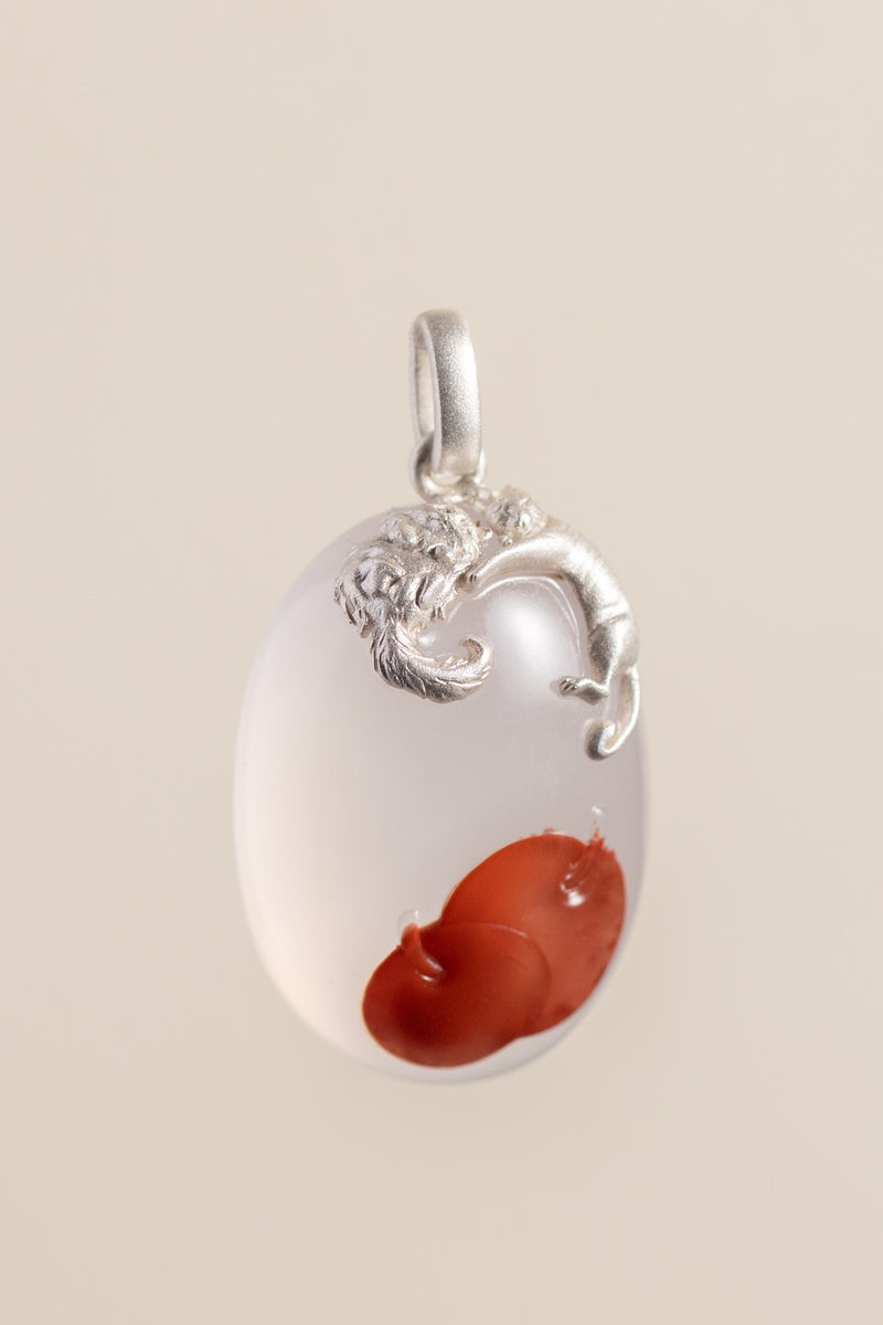 One small pendant holding two people, two cats, and the red the stone was already keeping for them.