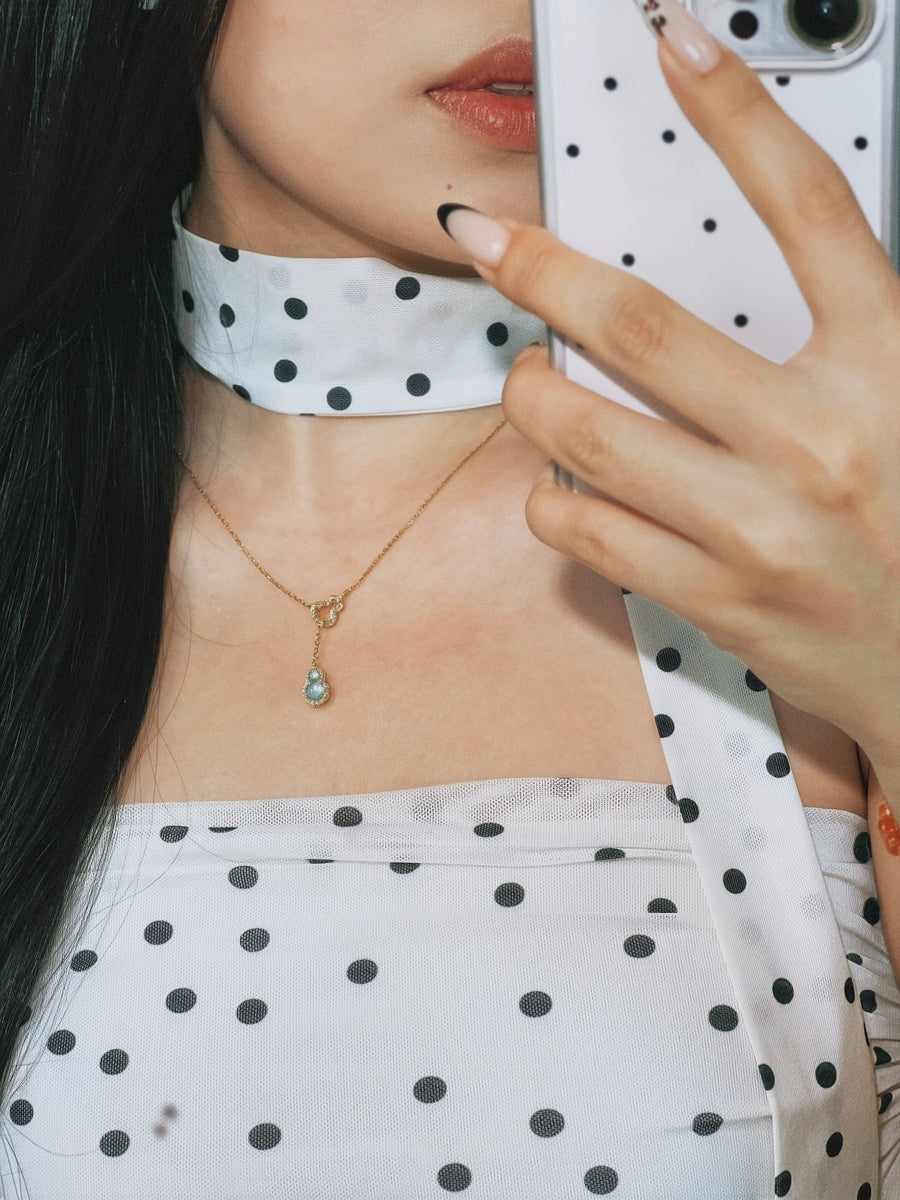 Customer styling a jadeite hulu necklace with a polka dot scarf