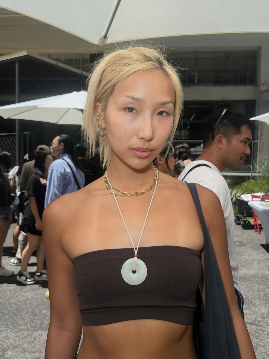 Customer wearing a large green quartzite jade donut necklace