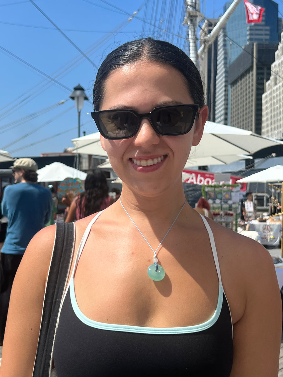 Customer wearing a sky blue xiuyu jade donut necklace outdoors